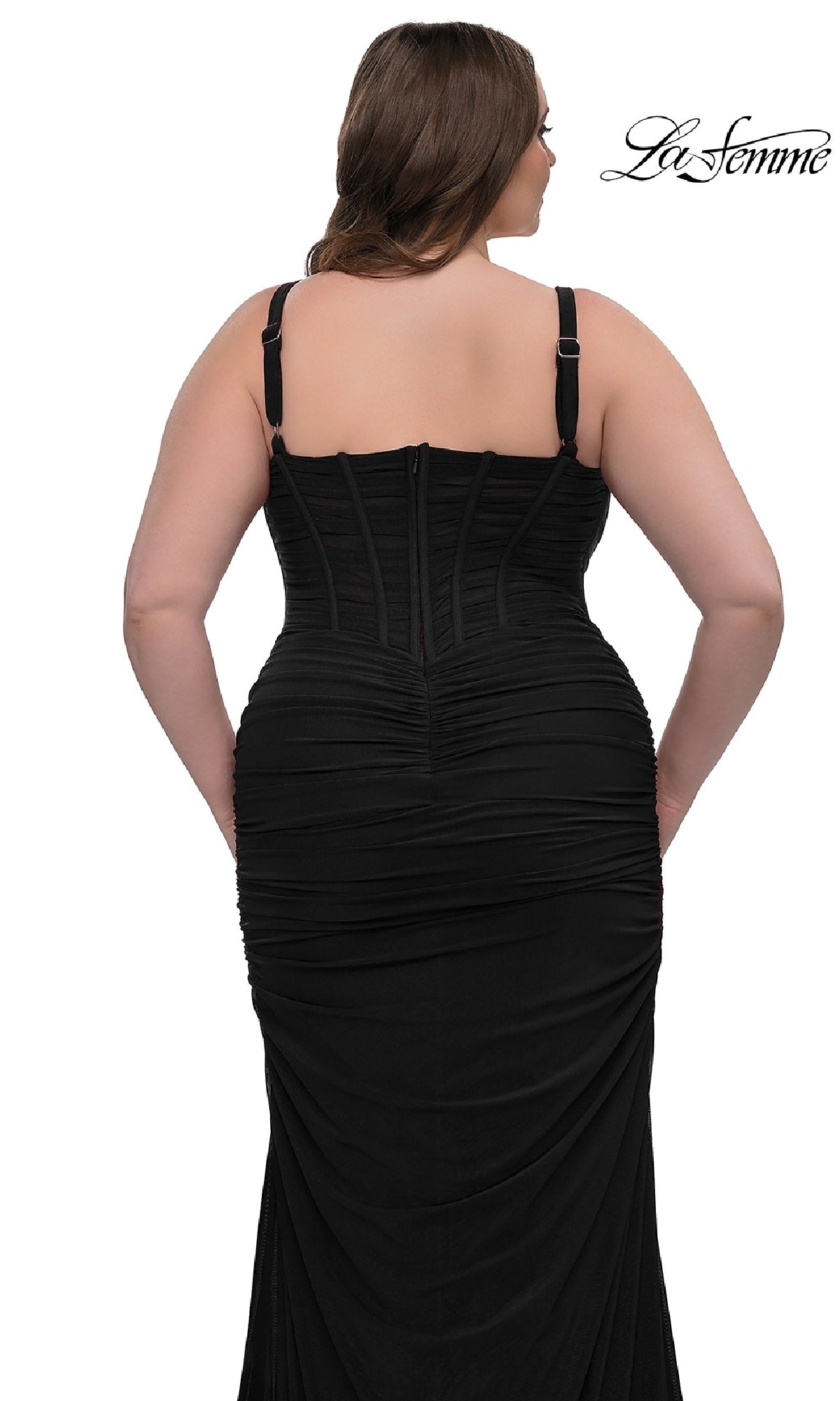A woman shown from the back wears the Plus-Size Sexy Long Prom Dress: La Femme 32402, a fitted black gown with ruching and visible corset-style bodice detail, standing against a white background.